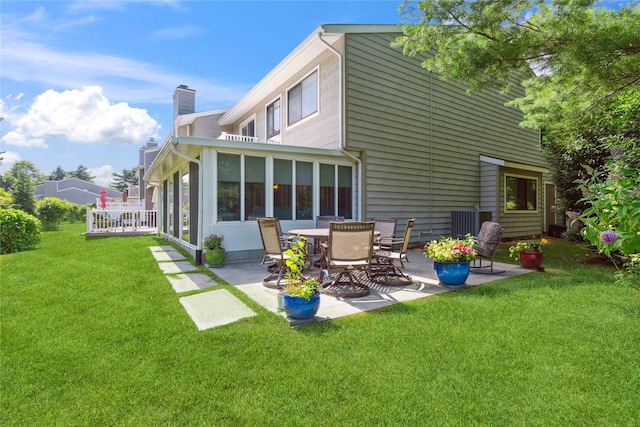 31 Boathouse Ln E, Bay Shore, NY 11706 - back of house featuring a patio area, a chimney, a yard, and a sunroom