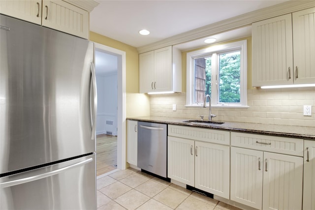 153 Park Ave, Manhasset, NY 11030 - kitchen featuring appliances with stainless steel finishes, backsplash, light tile patterned flooring, dark stone counters, and recessed lighting