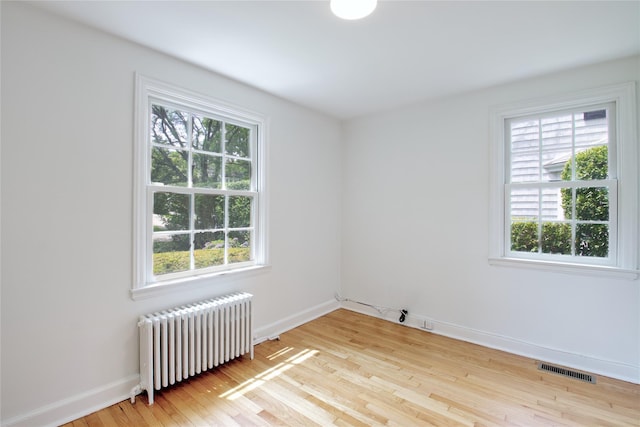 153 Park Ave, Manhasset, NY 11030 - empty room featuring radiator heating unit, plenty of natural light, and wood finished floors