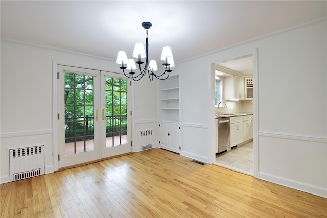 153 Park Ave, Manhasset, NY 11030 - unfurnished dining area featuring radiator heating unit, a chandelier, crown molding, light wood-style floors, and built in shelves