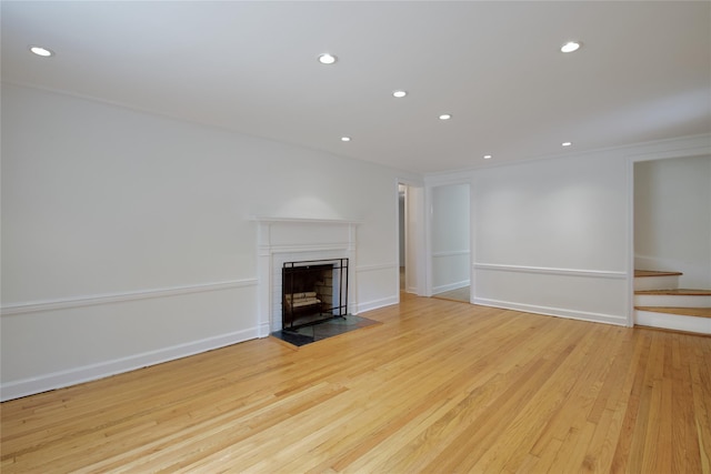 153 Park Ave, Manhasset, NY 11030 - unfurnished living room with a fireplace with flush hearth, recessed lighting, wood finished floors, and stairs