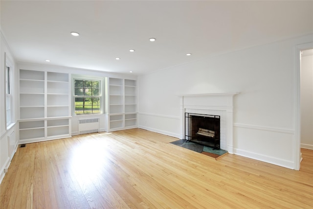 153 Park Ave, Manhasset, NY 11030 - unfurnished living room featuring radiator heating unit, light wood-style floors, a fireplace, built in shelves, and recessed lighting