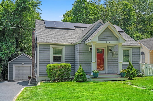 224 Woodbury Rd, Huntington, NY 11743 - view of front facade with asphalt driveway, roof with shingles, an outbuilding, a garage, and roof mounted solar panels