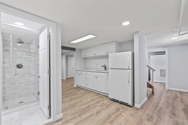 224 Woodbury Rd, Huntington, NY 11743 - kitchen featuring freestanding refrigerator, white cabinetry, light wood-style flooring, light countertops, and recessed lighting