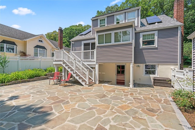 224 Woodbury Rd, Huntington, NY 11743 - back of property featuring stairs, solar panels, a patio area, and a fenced backyard