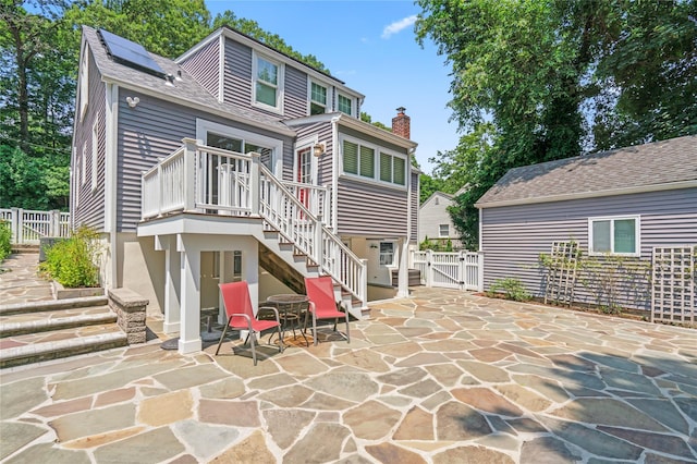 224 Woodbury Rd, Huntington, NY 11743 - rear view of house featuring a gate, stairway, a patio, solar panels, and a wooden deck