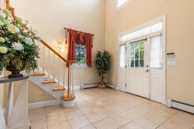 2 Apple Ct, Eastchester, NY 10709 - entrance foyer with healthy amount of natural light, tile patterned flooring, baseboard heating, stairway, and a high ceiling