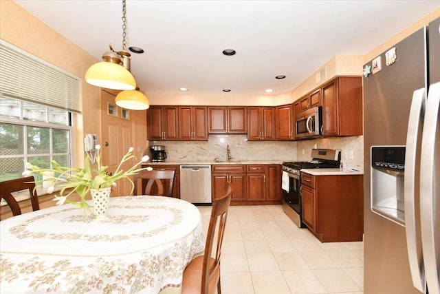 7 Albergo Ln, Syosset, NY 11791 - kitchen featuring stainless steel appliances, tasteful backsplash, brown cabinetry, light tile patterned flooring, and hanging light fixtures