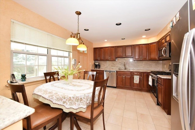 7 Albergo Ln, Syosset, NY 11791 - kitchen with stainless steel appliances, light countertops, tasteful backsplash, light tile patterned floors, and pendant lighting