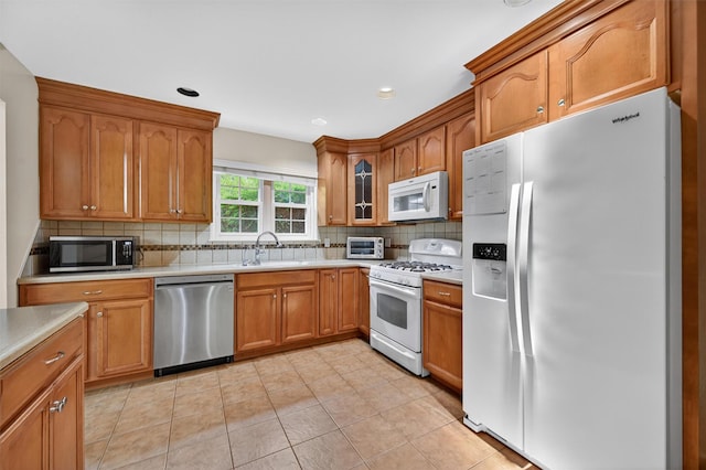 418 Pawnee Ct, Suffern, NY 10901 - kitchen with stainless steel appliances, light countertops, backsplash, brown cabinetry, and light tile patterned floors