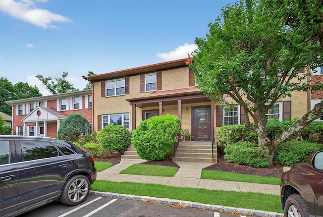 418 Pawnee Ct, Suffern, NY 10901 - colonial home with brick siding, covered porch, and uncovered parking