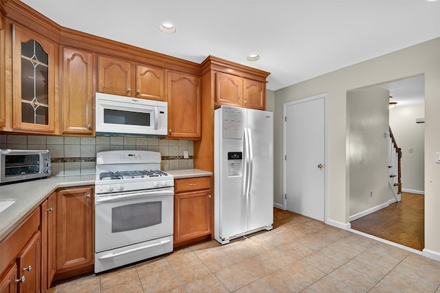 418 Pawnee Ct, Suffern, NY 10901 - kitchen with white appliances, light countertops, decorative backsplash, brown cabinetry, and recessed lighting