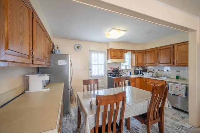 47 Cardinal Rd, Levittown, NY 11756 - kitchen featuring stainless steel appliances, under cabinet range hood, decorative backsplash, light countertops, and brown cabinets