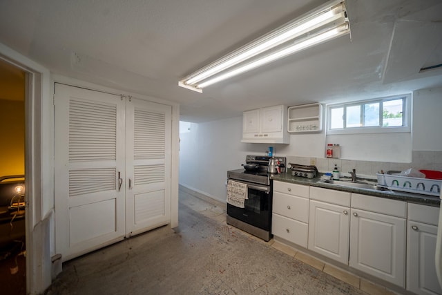 47 Cardinal Rd, Levittown, NY 11756 - kitchen with stainless steel electric range oven, under cabinet range hood, dark countertops, and white cabinets
