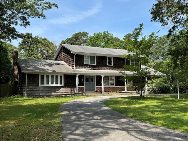 75 Topping Dr, Riverhead, NY 11901 - view of front of house with a front yard, curved driveway, a chimney, and a porch
