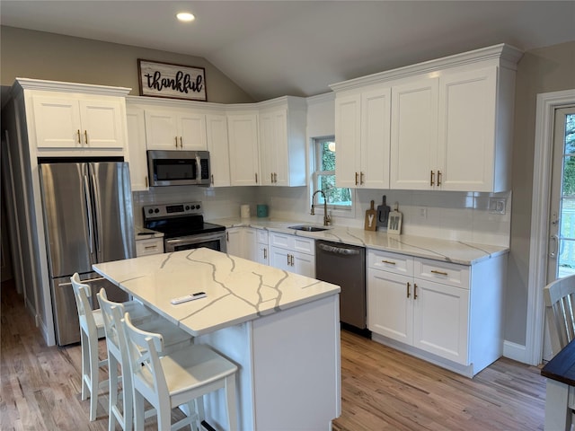 22 Bradish Ln, Babylon, NY 11702 - kitchen featuring appliances with stainless steel finishes, white cabinets, light wood-style floors, lofted ceiling, and recessed lighting
