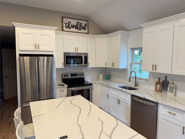 22 Bradish Ln, Babylon, NY 11702 - kitchen with stainless steel appliances, white cabinetry, tasteful backsplash, lofted ceiling, and light stone counters