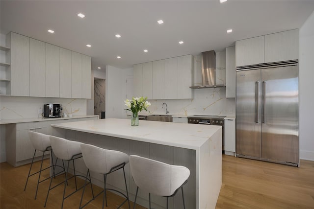 75 Red Fox Ln, Salt Point, NY 12578 - kitchen featuring stainless steel built in fridge, wall chimney range hood, modern cabinets, open shelves, and a kitchen bar