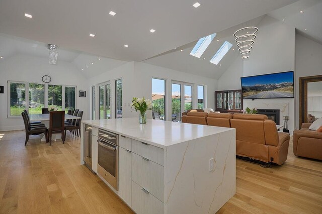 75 Red Fox Ln, Salt Point, NY 12578 - kitchen featuring modern cabinets, high vaulted ceiling, a skylight, oven, and a large island