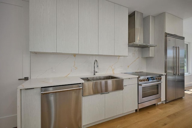 75 Red Fox Ln, Salt Point, NY 12578 - kitchen featuring appliances with stainless steel finishes, wall chimney exhaust hood, light countertops, light wood finished floors, and backsplash