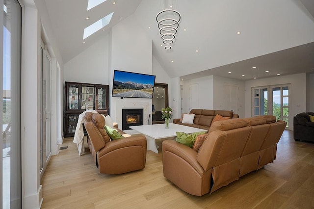 75 Red Fox Ln, Salt Point, NY 12578 - living room featuring high vaulted ceiling, a skylight, light wood-type flooring, a glass covered fireplace, and recessed lighting