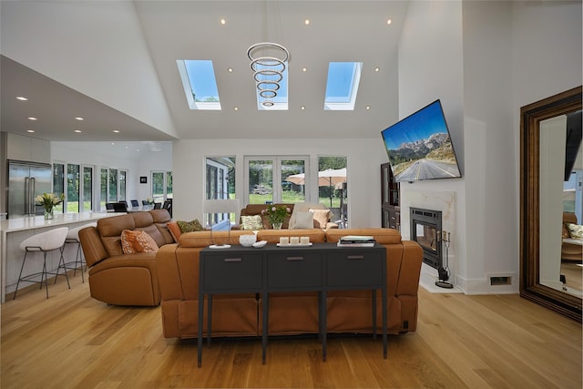 75 Red Fox Ln, Salt Point, NY 12578 - living area featuring high vaulted ceiling, a skylight, light wood finished floors, a fireplace with flush hearth, and plenty of natural light