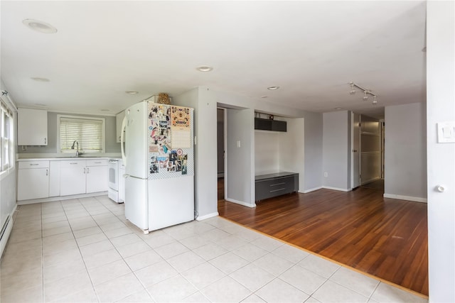 126 Tanglewylde Rd, Lake Peekskill, NY 10537 - kitchen with freestanding refrigerator, range, light countertops, light tile patterned floors, and white cabinetry