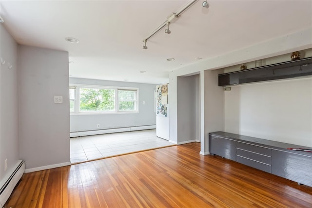 126 Tanglewylde Rd, Lake Peekskill, NY 10537 - spare room featuring a baseboard heating unit, rail lighting, wood finished floors, and recessed lighting