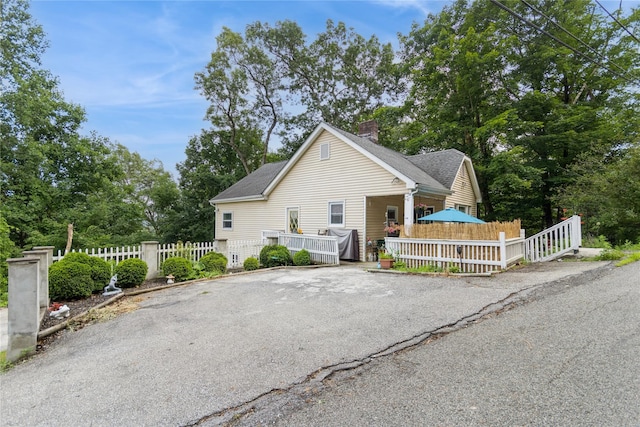 126 Tanglewylde Rd, Lake Peekskill, NY 10537 - view of front of house featuring a chimney and view of scattered trees