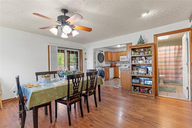 578 S St, Plattekill, NY 12528 - dining space with stacked washing machine and dryer, a textured ceiling, light wood-style flooring, and a ceiling fan