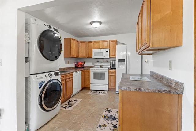 578 S St, Plattekill, NY 12528 - kitchen featuring white appliances, estacked washer and dryer, dark countertops, and brown cabinetry