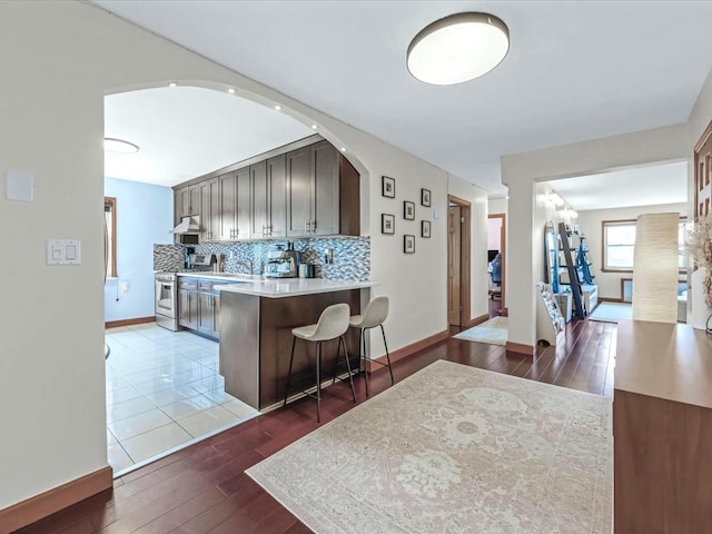 29-49 137th St Unit 6G, Flushing, NY 11354 - kitchen featuring light wood-style flooring, high end stainless steel range oven, a breakfast bar area, and light countertops