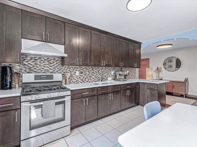 29-49 137th St Unit 6G, Flushing, NY 11354 - kitchen with stainless steel range with gas cooktop, under cabinet range hood, dark brown cabinetry, and backsplash