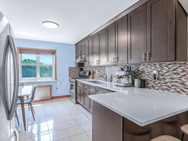 29-49 137th St Unit 6G, Flushing, NY 11354 - kitchen featuring stainless steel appliances, tasteful backsplash, a breakfast bar area, light countertops, and dark brown cabinetry