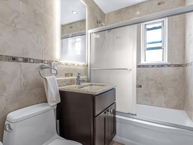 29-49 137th St Unit 6G, Flushing, NY 11354 - bathroom featuring combined bath / shower with glass door, vanity, and tile walls