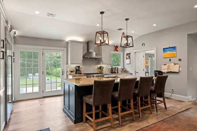 24 Canvasback Ln, East Quogue, NY 11942 - kitchen with vaulted ceiling, a center island with sink, healthy amount of natural light, a breakfast bar, and recessed lighting