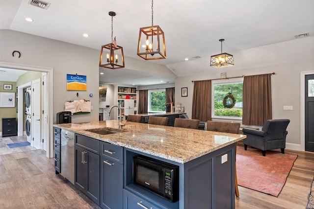 24 Canvasback Ln, East Quogue, NY 11942 - kitchen with stacked washer / dryer, open floor plan, lofted ceiling, light wood-type flooring, and black microwave
