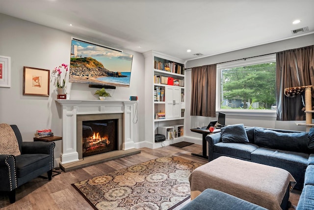 24 Canvasback Ln, East Quogue, NY 11942 - living area with wood finished floors, a glass covered fireplace, and recessed lighting