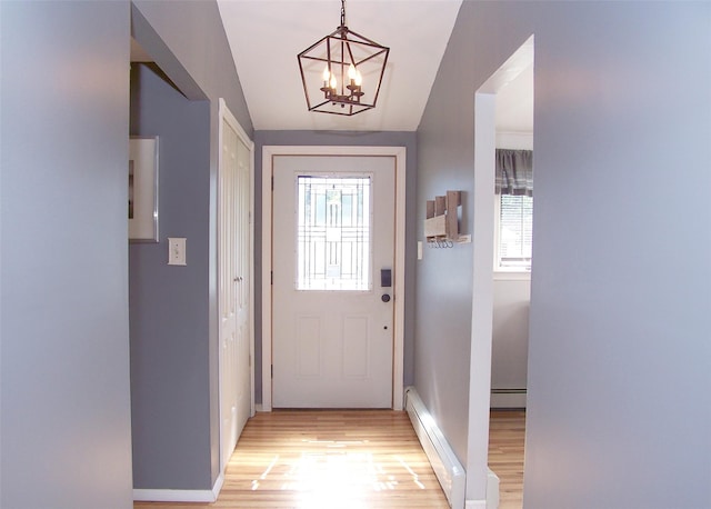 5 Windham Ln, Ronkonkoma, NY 11779 - entryway with baseboard heating, light wood finished floors, a chandelier, and vaulted ceiling