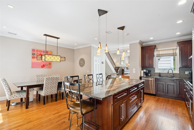 28 The Mews, Syosset, NY 11791 - kitchen with stainless steel dishwasher, a kitchen breakfast bar, light wood-type flooring, hanging light fixtures, and recessed lighting