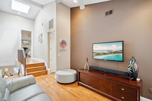 28 The Mews, Syosset, NY 11791 - living area with high vaulted ceiling, a skylight, light wood-style flooring, stairs, and a ceiling fan