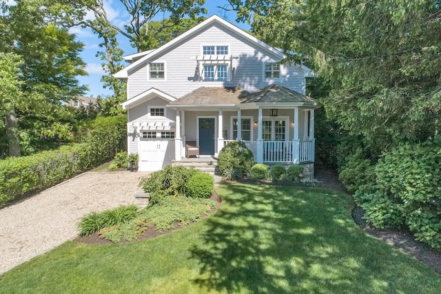 3120 Grathwohl Rd, New Suffolk, NY 11956 - view of front of home featuring dirt driveway, an attached garage, a porch, a front yard, and a shingled roof