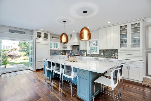3120 Grathwohl Rd, New Suffolk, NY 11956 - kitchen with custom range hood, backsplash, a kitchen breakfast bar, white cabinets, and crown molding