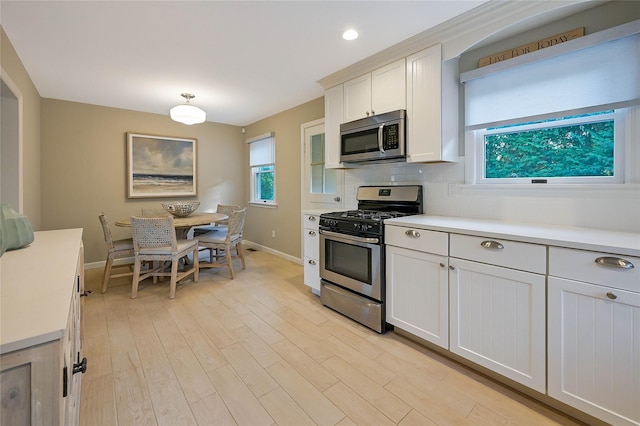 3120 Grathwohl Rd, New Suffolk, NY 11956 - kitchen featuring appliances with stainless steel finishes, light countertops, light wood-style floors, tasteful backsplash, and recessed lighting