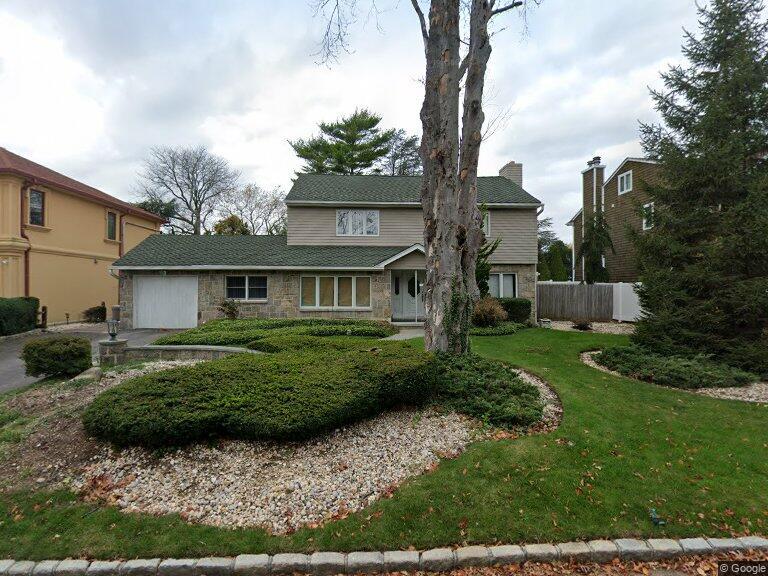 1554 Hewlett Heath Rd, Hewlett, NY 11557 - traditional home with stone siding and a garage