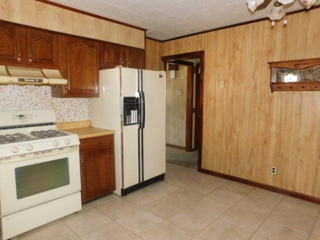 967 State Route 17k, Montgomery, NY 12549 - kitchen featuring white appliances, under cabinet range hood, wooden walls, and light countertops