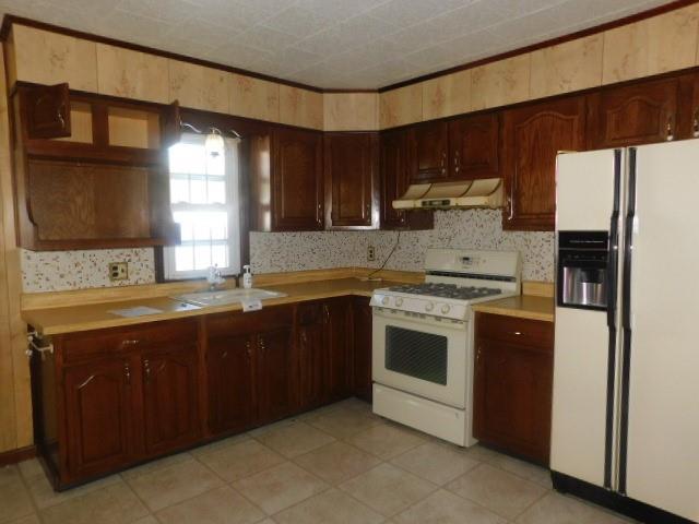 967 State Route 17k, Montgomery, NY 12549 - kitchen with white appliances, exhaust hood, light countertops, decorative backsplash, and light tile patterned floors