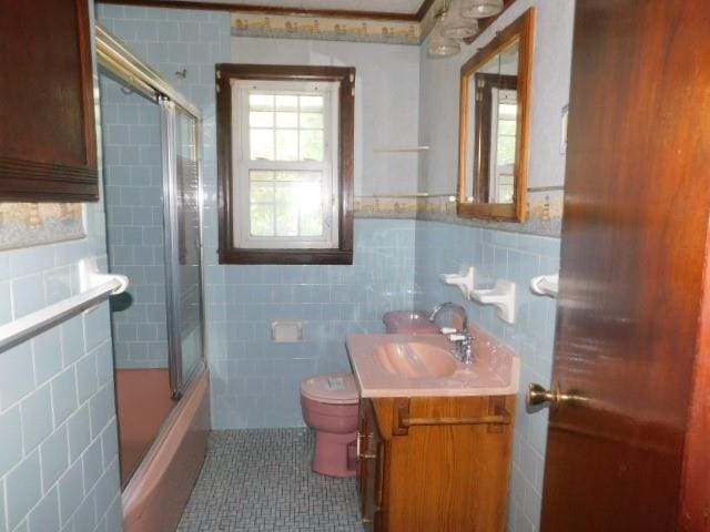 967 State Route 17k, Montgomery, NY 12549 - bathroom featuring tile walls, vanity, bath / shower combo with glass door, tile patterned flooring, and a wainscoted wall