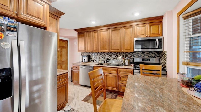 20 Overhill Pl, Yonkers, NY 10704 - kitchen with appliances with stainless steel finishes, tasteful backsplash, brown cabinets, light stone countertops, and recessed lighting