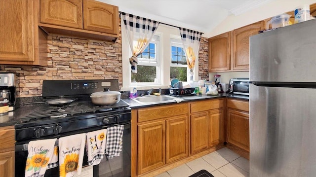 20 Overhill Pl, Yonkers, NY 10704 - kitchen featuring freestanding refrigerator, black gas stove, light tile patterned flooring, brown cabinetry, and vaulted ceiling